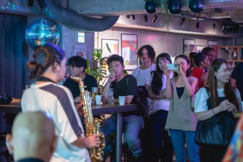 a group of people in a bar playing saxophone at UNPLAN Shinjuku in Tokyo