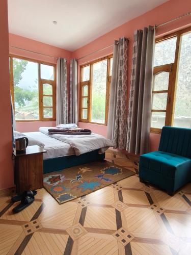 a bedroom with a bed and a chair and windows at Julley Jispa in Jispa