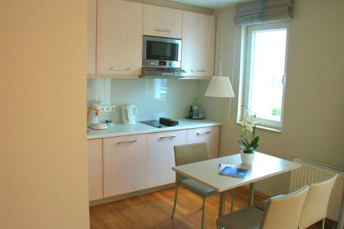 a small kitchen with a table and a microwave at Nymphe Strandhotel & Apartments in Binz