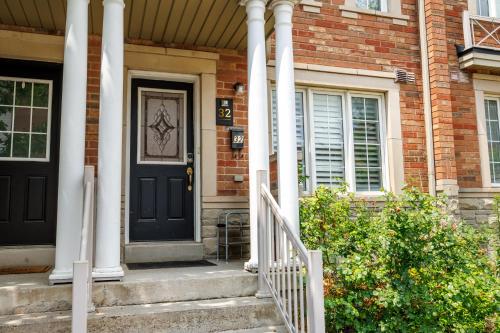 a brick house with a black door and white columns at Semi-Private Townhouse - 3 Bedrooms, 4 beds, Free Parking, Wifi, Netflix, - Hosted by Matthew in Toronto