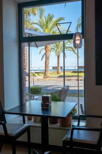 a table in a room with a view of the beach at Hotel Miramare in Pietra Ligure