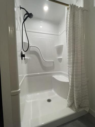 eine weiße Badewanne mit Duschvorhang im Badezimmer in der Unterkunft The Brickworks at the 1896 Building in Kaslo