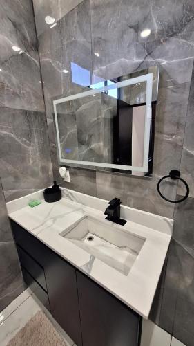 a bathroom with a white sink and a mirror at Greivin House in Santa María