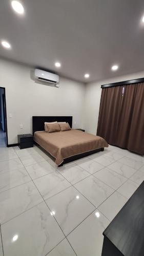 a bedroom with a large bed in a white room at Greivin House in Santa María
