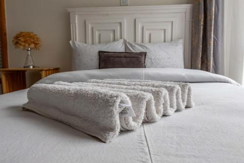 a white blanket laying on top of a bed at Bellora Urban Homes in Ongata Rongai 
