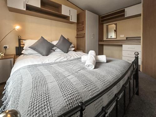 a bedroom with a large bed with towels on it at The Fern caravan 17 in Angus