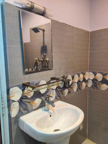a bathroom with a sink and a mirror at Durbar Home Apartments in Tribhuwan Airport