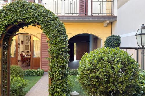 an archway in front of a building with bushes at Il Giardinetto Rooms in Ferrara