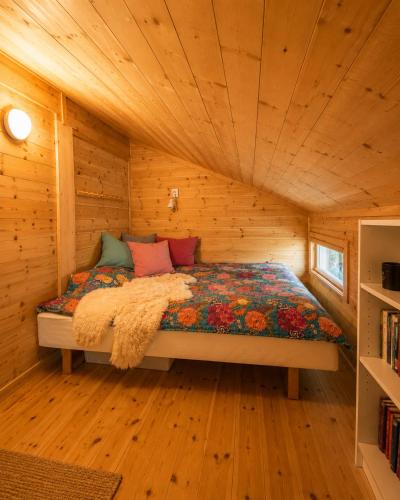 a bed in a room with a wooden ceiling at Grand Mountain Lodge Filefjell in Tyinkrysset