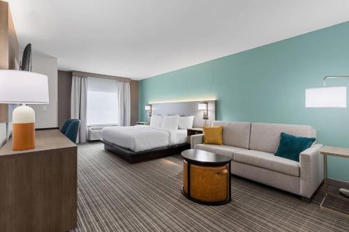 a hotel room with a bed and a couch at Comfort Inn & Suites Marion I-57 in Marion