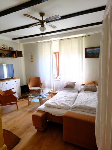 a bedroom with a bed and a living room at Búj-Lak Vendégház in Zalaszentmárton