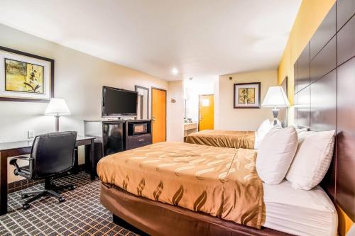 a hotel room with two beds and a desk at Quality Inn Carbondale University area in Carbondale