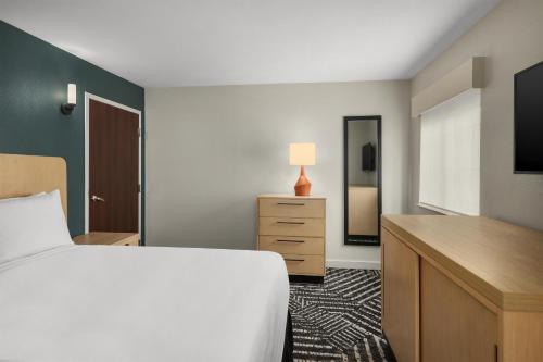a bedroom with a bed and a dresser and a tv at Hyatt House Morristown in Morristown