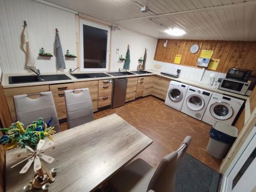 a kitchen with a table and washing machines at Wanderhütte Woody in Schwarzbach