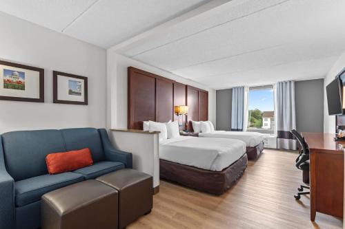 a hotel room with two beds and a couch at Comfort Suites Manassas Battlefield Park in Manassas