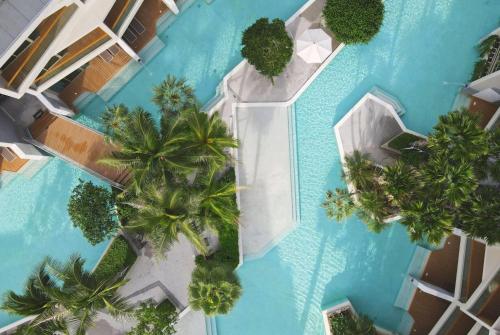 an overhead view of a swimming pool with palm trees at Wyndham Grand Nai Harn Beach Phuket in Nai Harn Beach