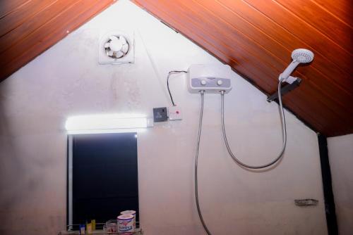 a bathroom with a mirror and a hair dryer at Grounder's River Cabin in Nanu Oya
