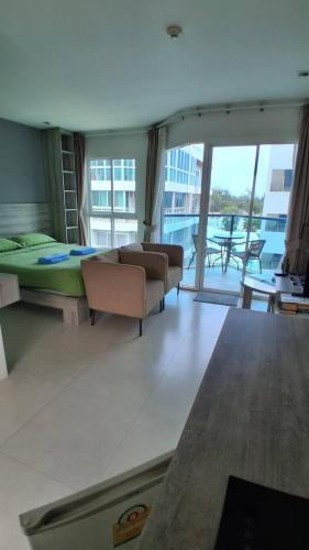 a bedroom with a bed and a couch and a balcony at Grandblue condominium 602 in Ban Tha Fat