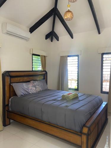 a bedroom with a large bed in a room with windows at Mana Backpacker and Dive Resort in Nadi