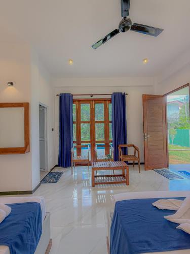 a bedroom with two beds and a living room at Nilwadula Hotel Udawalawe in Ratkarawwa