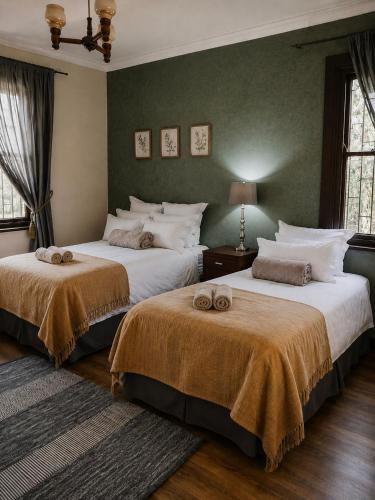 a bedroom with two beds with towels on them at De Mist Graskop in Graskop