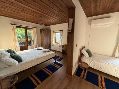 a bedroom with two beds and a window at Капсъзовата къща in Leshten