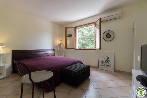 a bedroom with a bed and a table and a window at La maison imart in Revel