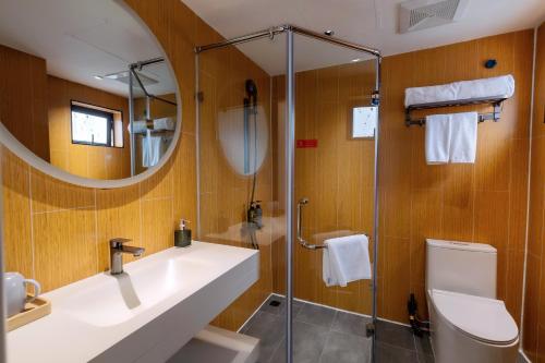 a bathroom with a sink and a shower with a mirror at Hera Hotel in Hanoi