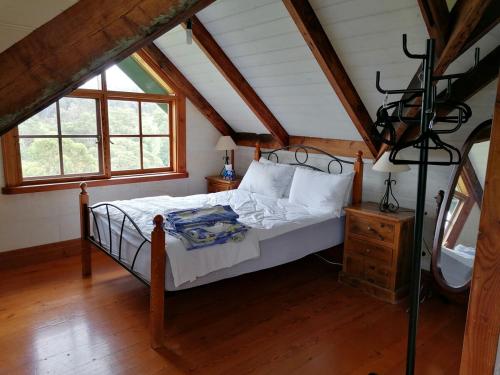 a bedroom with a bed in a attic at Hank's Folly in Wapengo