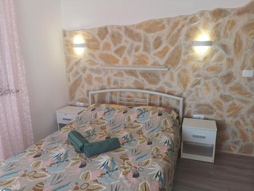 a bedroom with a bed with a stone wall at Apartment Alina in Umag