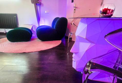 a room with purple and green chairs and a table at Domaine de la Besnerie Gites avec SPA Privatif à 10 min du Mont St Michel in Tanis