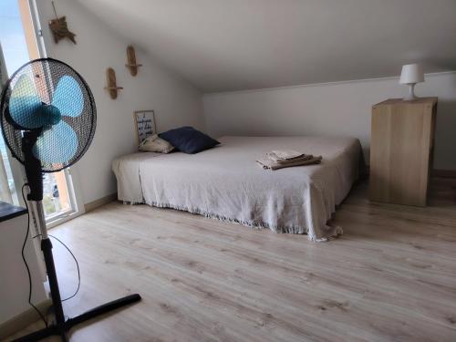 a bedroom with a bed and a fan at La Petite in Cogoleto