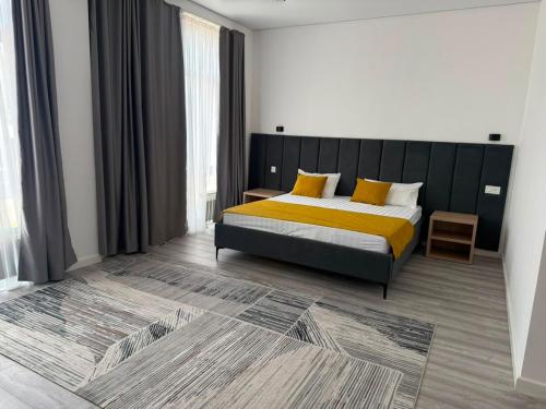 a bedroom with a bed with yellow sheets and yellow pillows at TUMAR hotel in Zhezdi