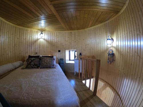 a bedroom with a bed in a room with wooden walls at Penacova Moinho do Ligeiro near Coimbra in Penacova