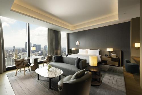 a hotel room with a king bed and a living room at Conrad Nagoya in Nagoya