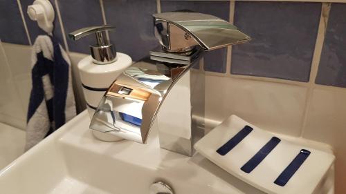 - un robinet en argent placé sur un lavabo dans la salle de bains dans l'établissement Suquet26, à Cannes