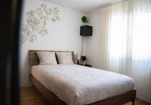 a bedroom with a bed with a television and a window at La parenthèse Provençale in Viry-Châtillon