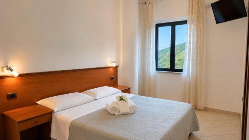 a hotel room with a bed with a purse on it at Locanda Adele in Parghelia