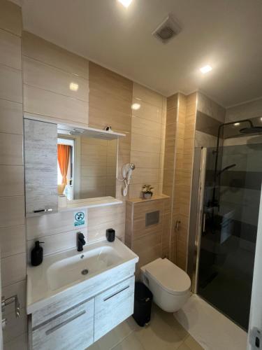 a bathroom with a sink and a toilet and a shower at Hotel Vezir Palace in Travnik