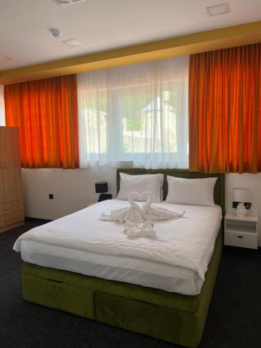 a bedroom with a large bed with a ribbon on it at Hotel Vezir Palace in Travnik