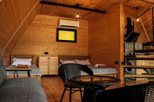 a room with two beds and a table and chairs at Machakhela Peaks in Sindietʼi