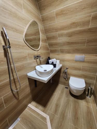 a bathroom with a sink and a toilet and a mirror at Machakhela Peaks in Sindietʼi