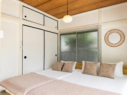 a bedroom with a bed with white walls and a window at #39 Ukimafunado in Tokyo