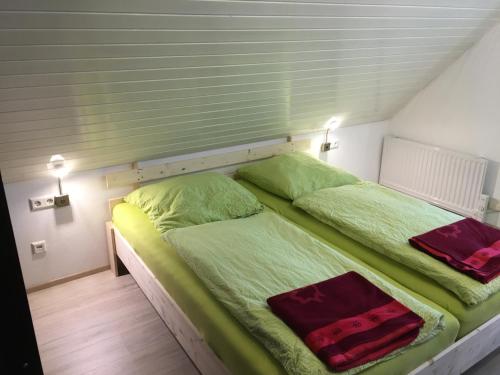 1 Schlafzimmer mit 2 Betten und grüner Bettwäsche in der Unterkunft Ferienwohnung am Bodensee in Kressbronn am Bodensee
