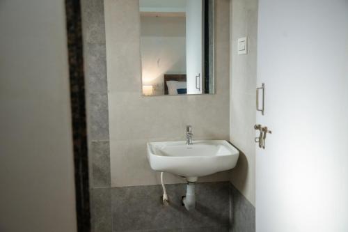 a bathroom with a sink and a mirror at Sushi Greens Suites in Dāvangere