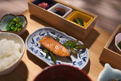 a table with a plate of food with rice and vegetables at Nishihoppo Onsen HOTEL in Yamanouchi