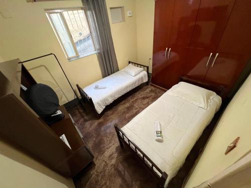 a small room with two beds and a mirror at Casa no Centro, 3 Camas, Garagem, com Netflix e Amazon Prime in Rio das Flores