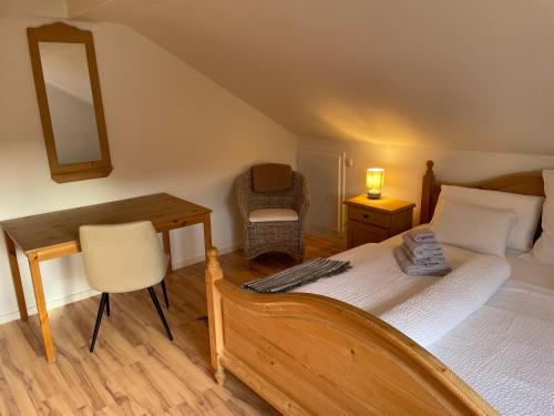 a bedroom with a bed and a desk and a chair at Ferienwohnungen Mews in Immenstadt im Allgäu