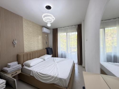 a bedroom with a white bed and a window at Shengjin Apartament 5 M in Shëngjin