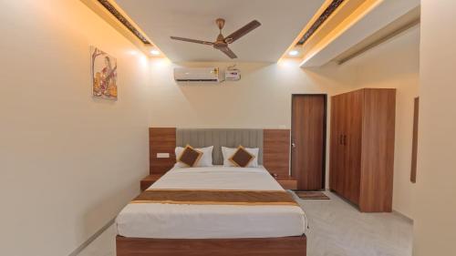 a bedroom with a bed and a ceiling fan at Hotel Otel Besa in Nagpur